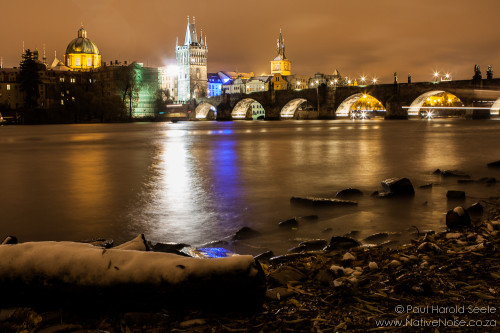 Vltava river and the Charles Bridge on a snowy night in Prague